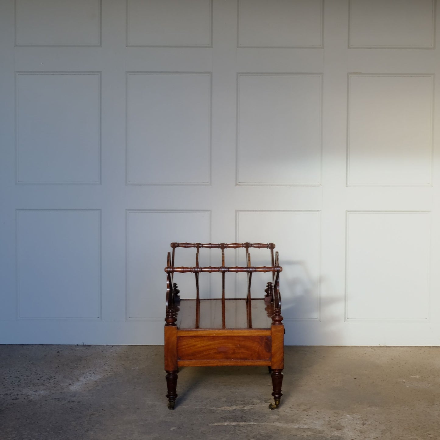 A beautiful mahogany canterbury, circa 1820, with five cross framed dividers incorporating a laurel wreath motif. With a single drawer below and raised on turned legs with original castors. In very good condition.