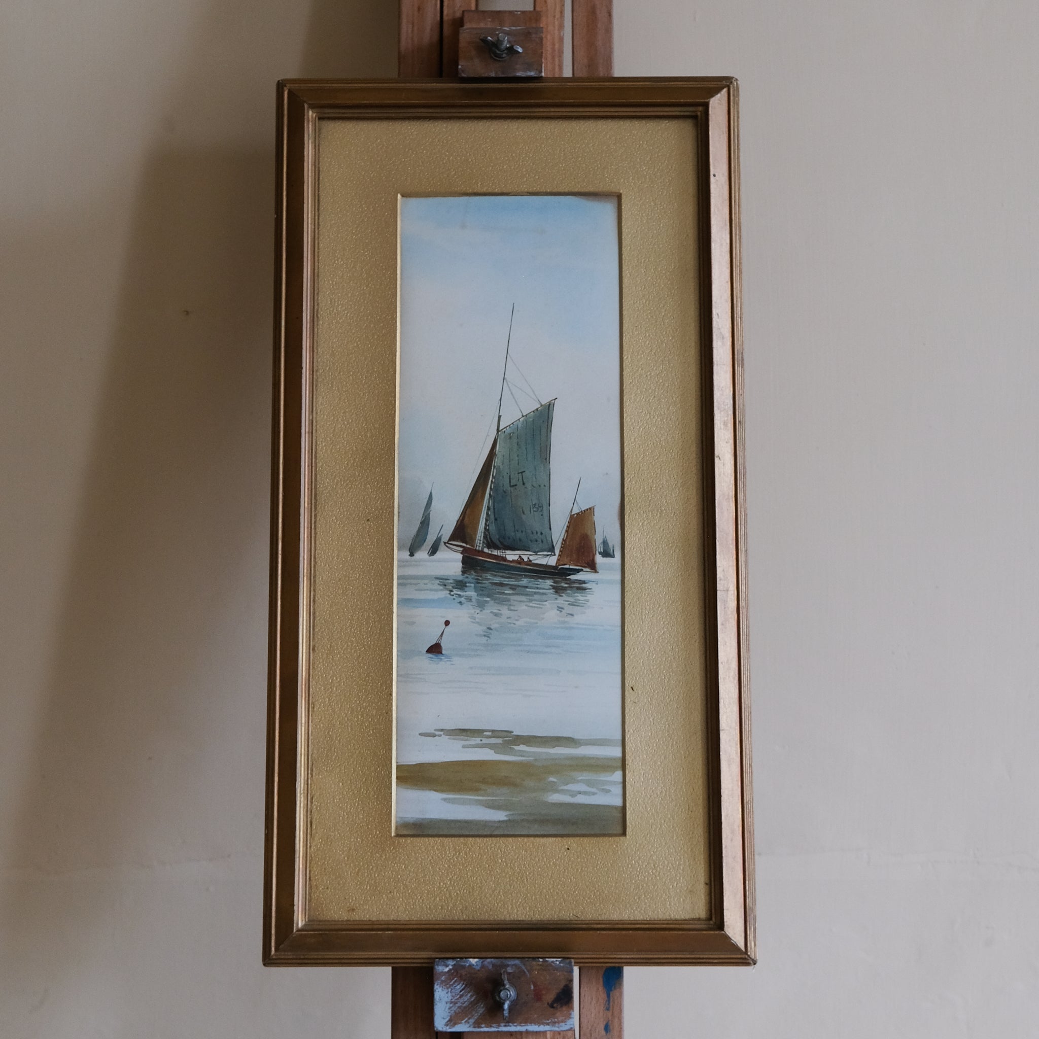 Framed artwork of sailboats on a water surface with a gold frame.