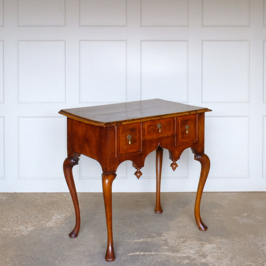 A George I walnut and feather banded side table, c. 1720. Inlaid detail to the top and a shaped apron with finials, likely added later. A delightful patina commensurate with age throughout.