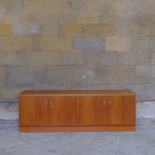 A low teak mid century sideboard by G Plan. Two spacious cabinets, each with a pair of doors and single internal shelf. The maker's mark is present inside one of the doors. In lovely condition, with some very light marks to the top, commensurate with the item's age.