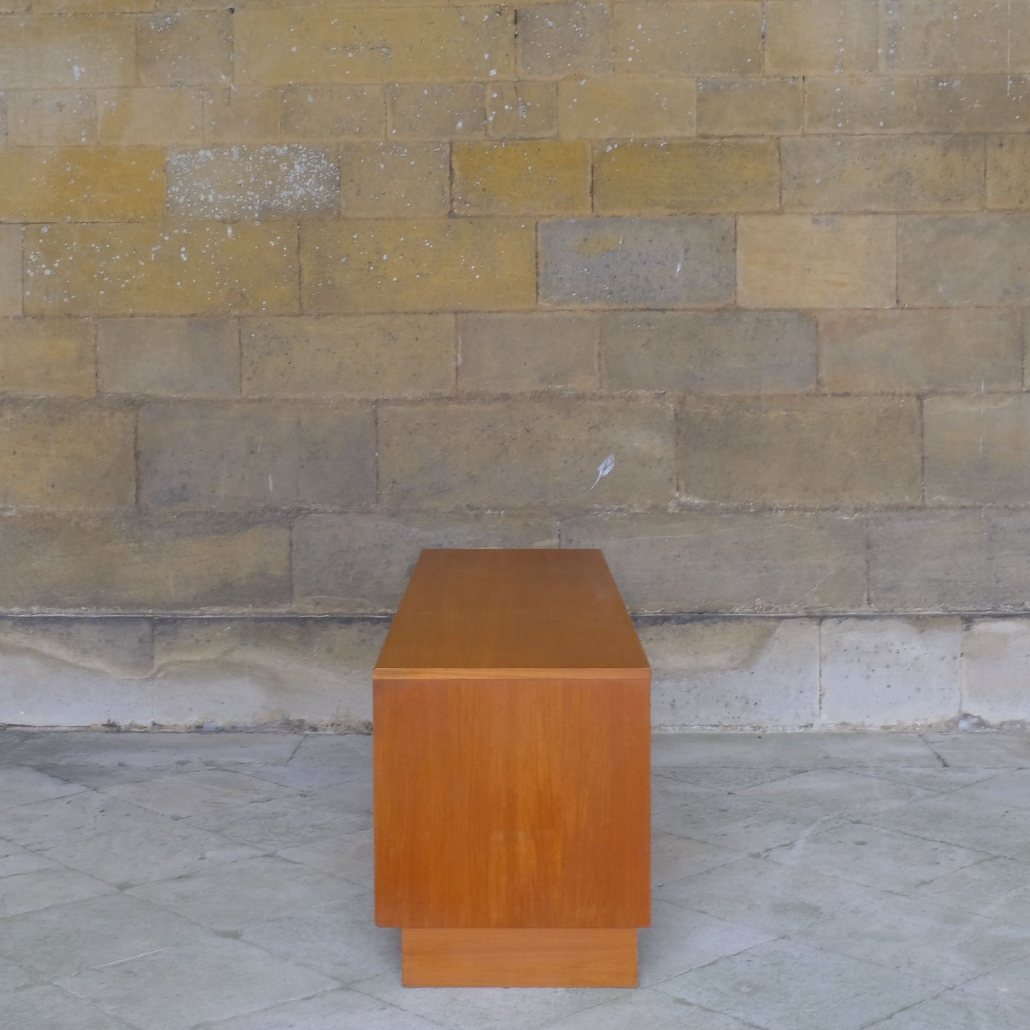 A low teak mid century sideboard by G Plan. Two spacious cabinets, each with a pair of doors and single internal shelf. The maker's mark is present inside one of the doors. In lovely condition, with some very light marks to the top, commensurate with the item's age.