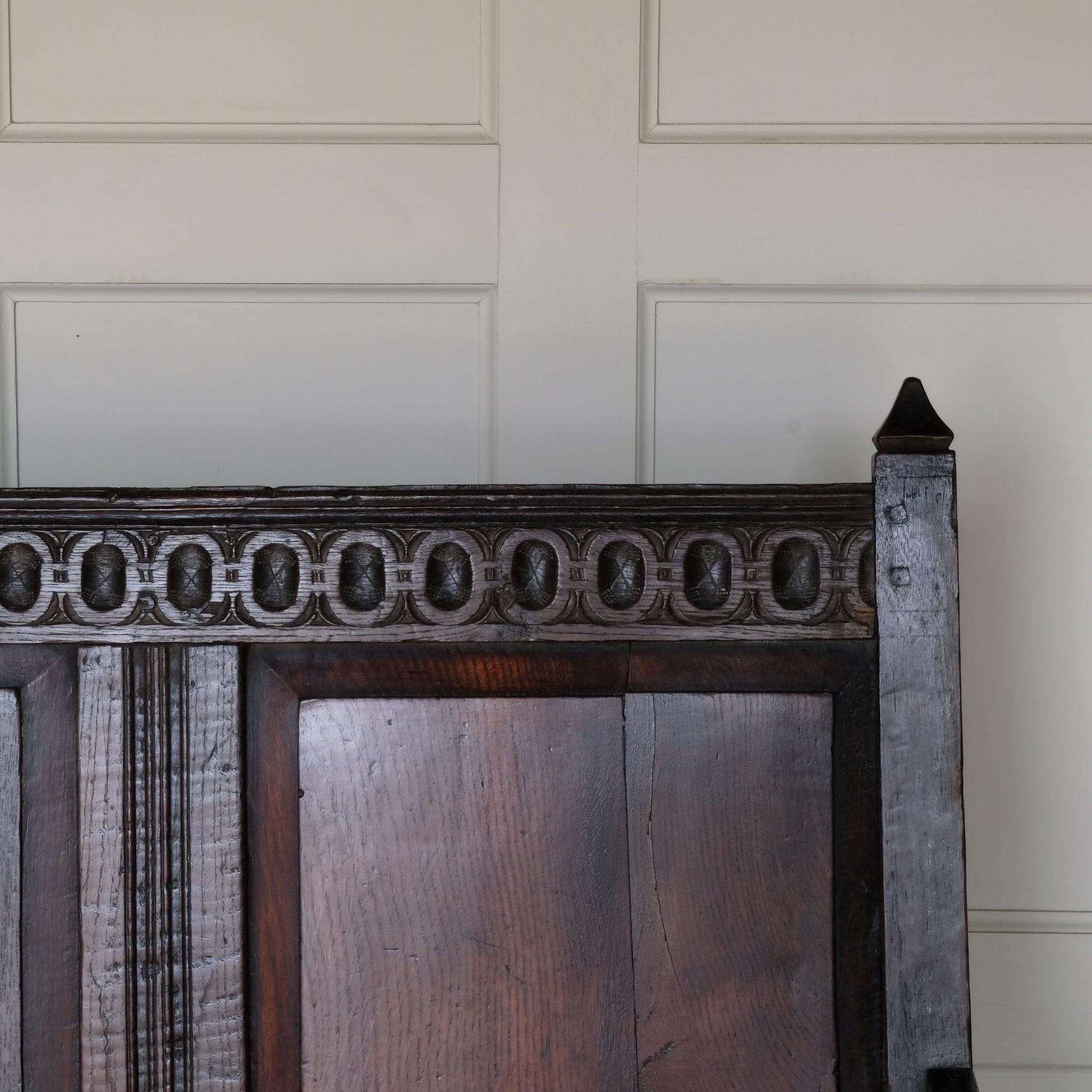 An exquisite 18th century oak settle with a carved back panel on turned legs with a barley twist front stretcher. In good, sturdy condition with a really beautiful, rich patina. The seat has been re-corded, and a new feather cushion made for it, upholstered in "Thika" by Jim Thompson, sourced from Haines Collection. Below this cushion sits a slim pad which has been made to protect the upholstery from wear from the cording.