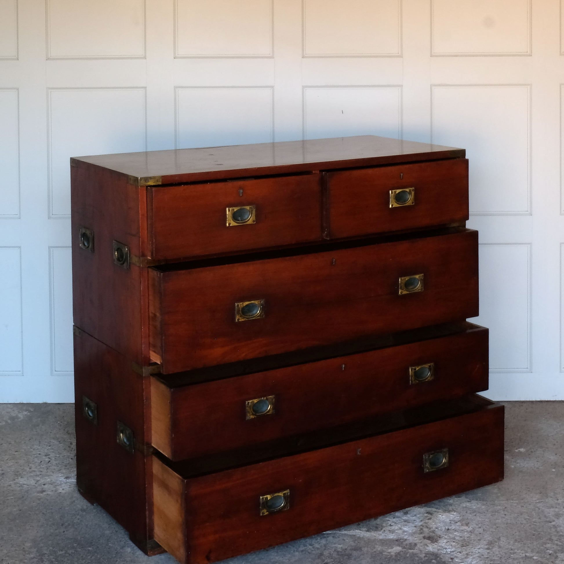 A beautiful brass bound mahogany campaign chest, early 19th century, comprised of two sections with two short over three long drawers with recessed brass handles on the drawers and sides, with a gentle patina commensurate with its age and use, the drawers in excellent working condition. Splits into two for easy manoeuvre. It would make a distinctive and attractive addition to a bedroom or hallway.