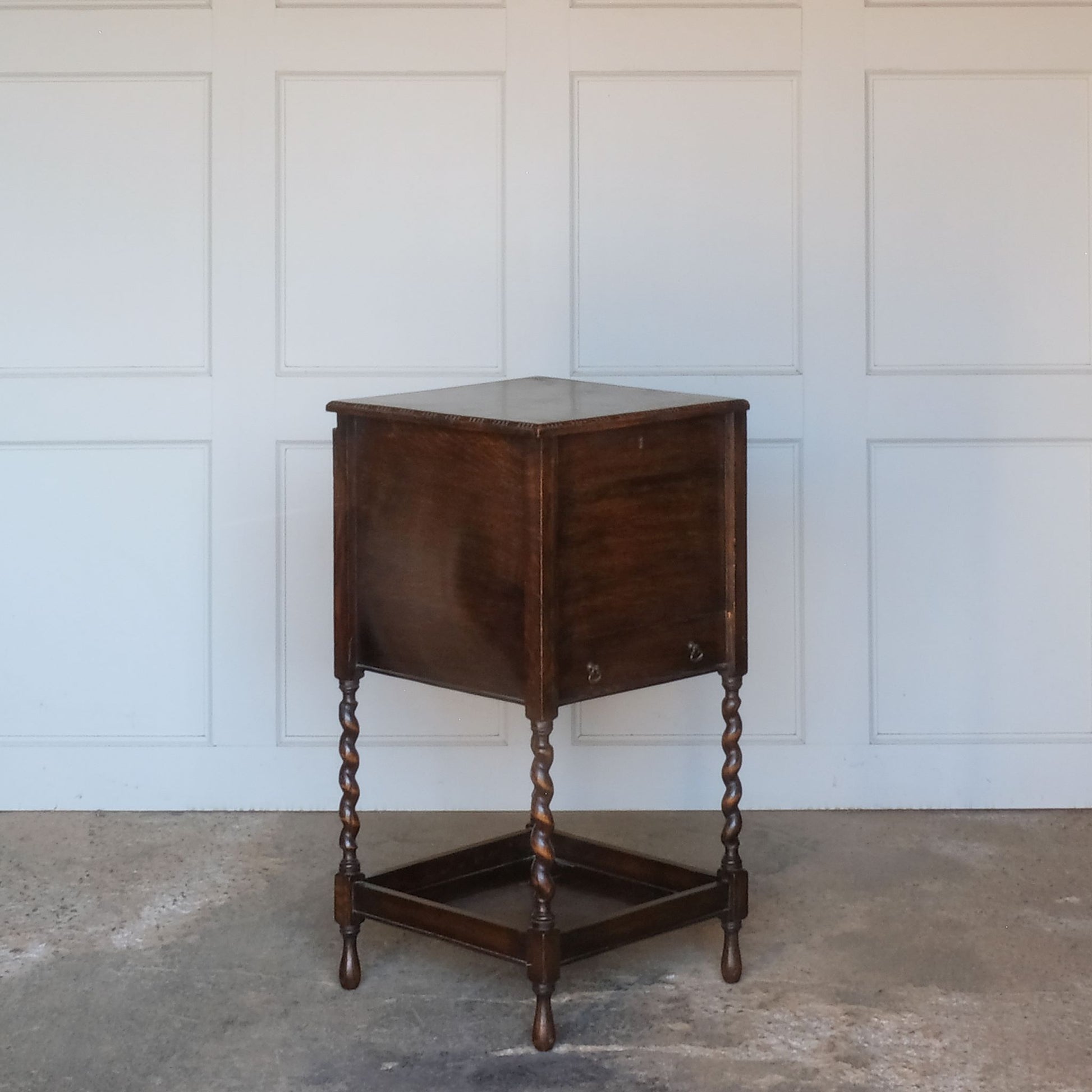 A late 19th / early 20th century oak sewing table, with a hinged top and single drawer below, on elegant barley twist supports over a single shelf and turned feet, the interior of the upper cabinet and drawer lined with burnt orange silk padding, with some age related patina, in very good condition. It would make a lovely bedside table.
