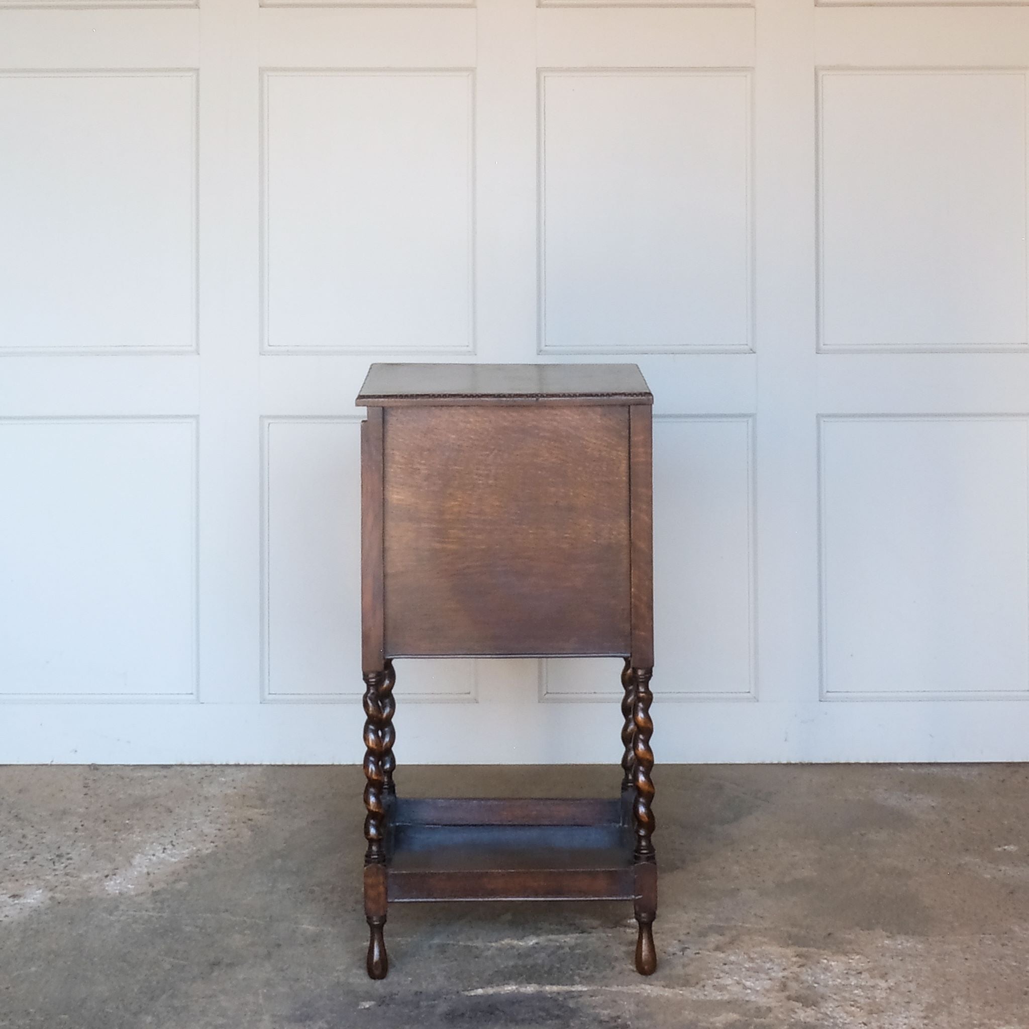 A late 19th / early 20th century oak sewing table, with a hinged top and single drawer below, on elegant barley twist supports over a single shelf and turned feet, the interior of the upper cabinet and drawer lined with burnt orange silk padding, with some age related patina, in very good condition. It would make a lovely bedside table.