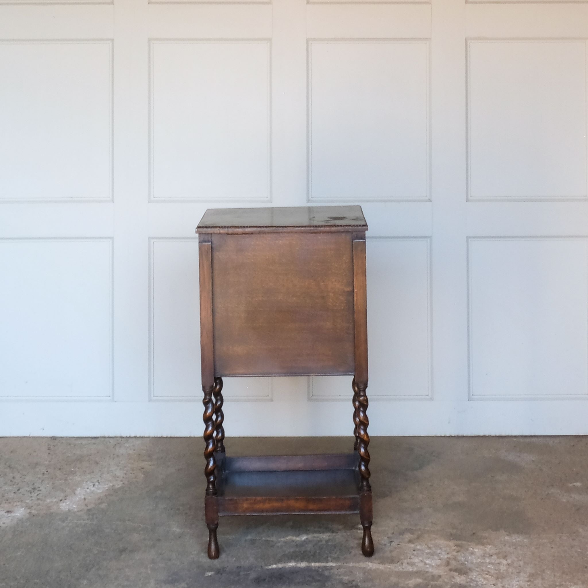 A late 19th / early 20th century oak sewing table, with a hinged top and single drawer below, on elegant barley twist supports over a single shelf and turned feet, the interior of the upper cabinet and drawer lined with burnt orange silk padding, with some age related patina, in very good condition. It would make a lovely bedside table.