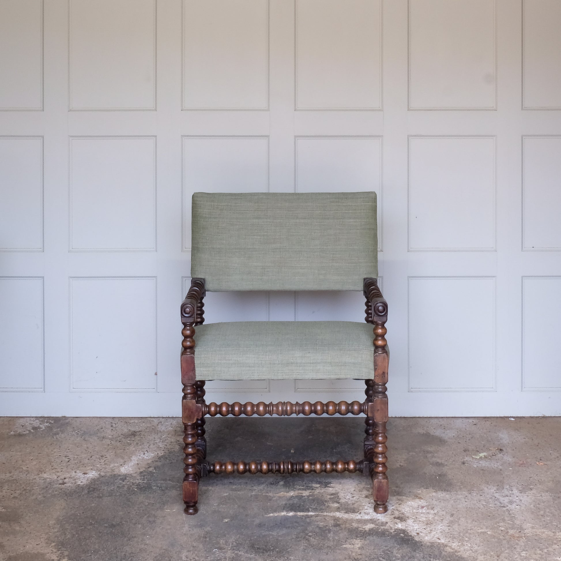 A late 17th Century walnut Bobbin turned armchair, the rectangular padded back and seat base upholstered in green Byram by Colefax and Fowler, the turned arm rests with block terminals and circular mouldings raised on turned legs and stretchers, in very good sturdy condition