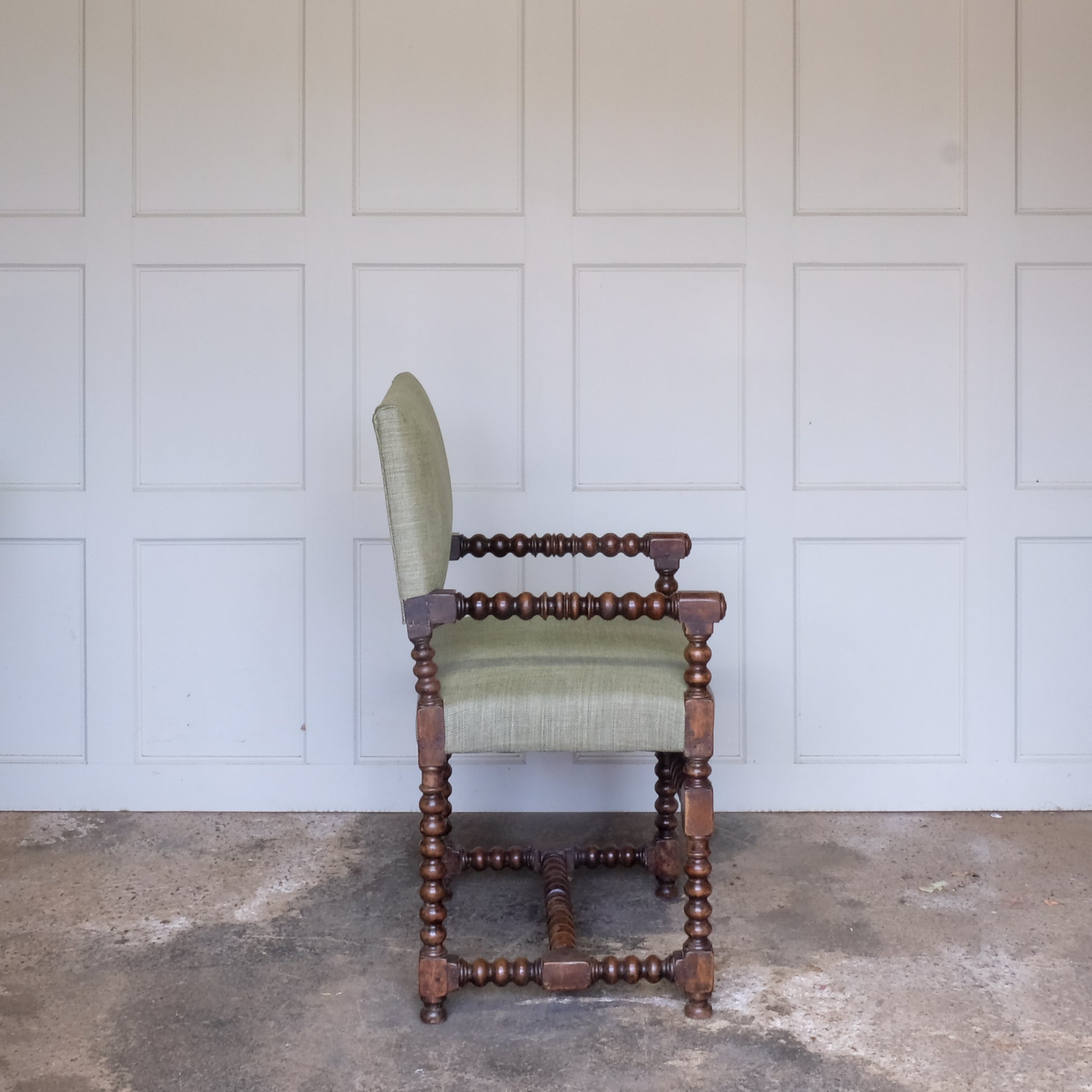 A late 17th Century walnut Bobbin turned armchair, the rectangular padded back and seat base upholstered in green Byram by Colefax and Fowler, the turned arm rests with block terminals and circular mouldings raised on turned legs and stretchers, in very good sturdy condition