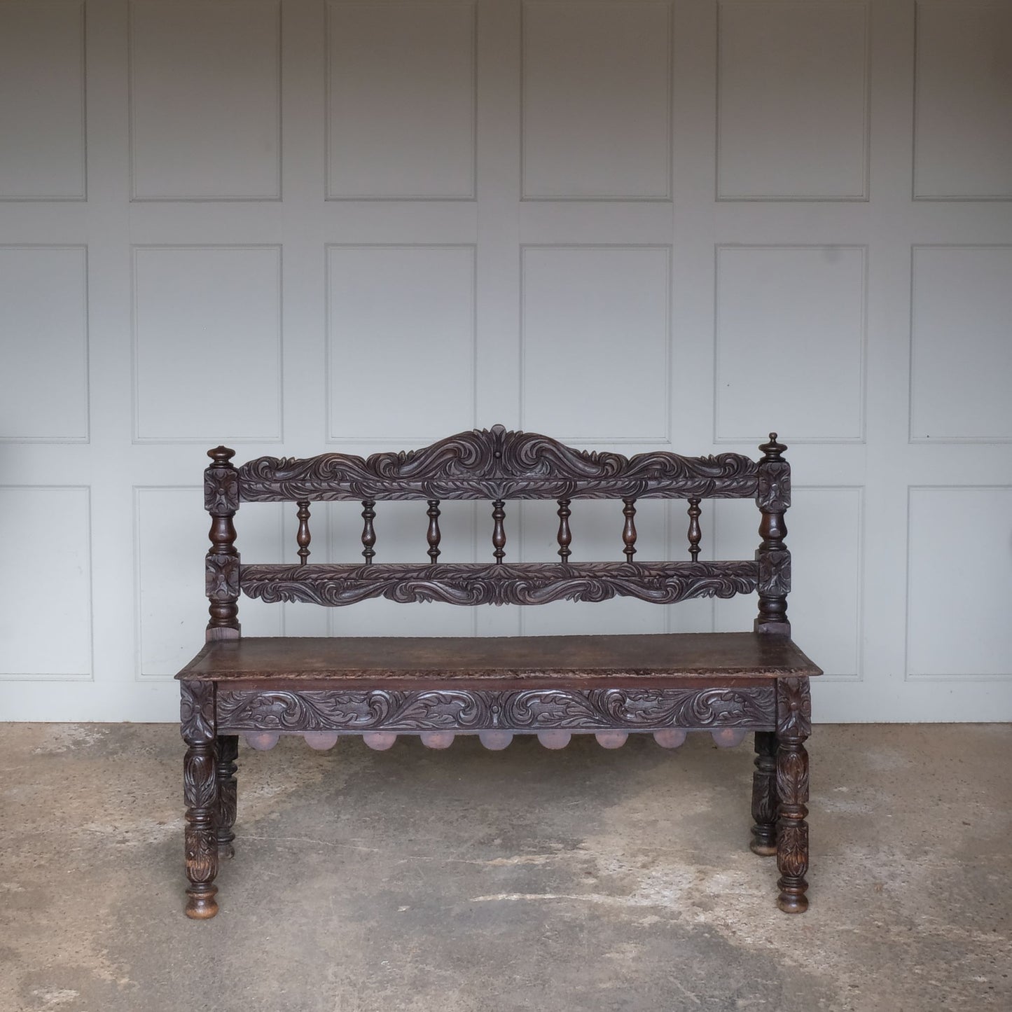 A small oak carved bench, perfect for children, late 19th / early 20th century. With a beautiful foliate carved design. A repaired split to the back rest, in sturdy condition but showing signs of a long and well loved life.