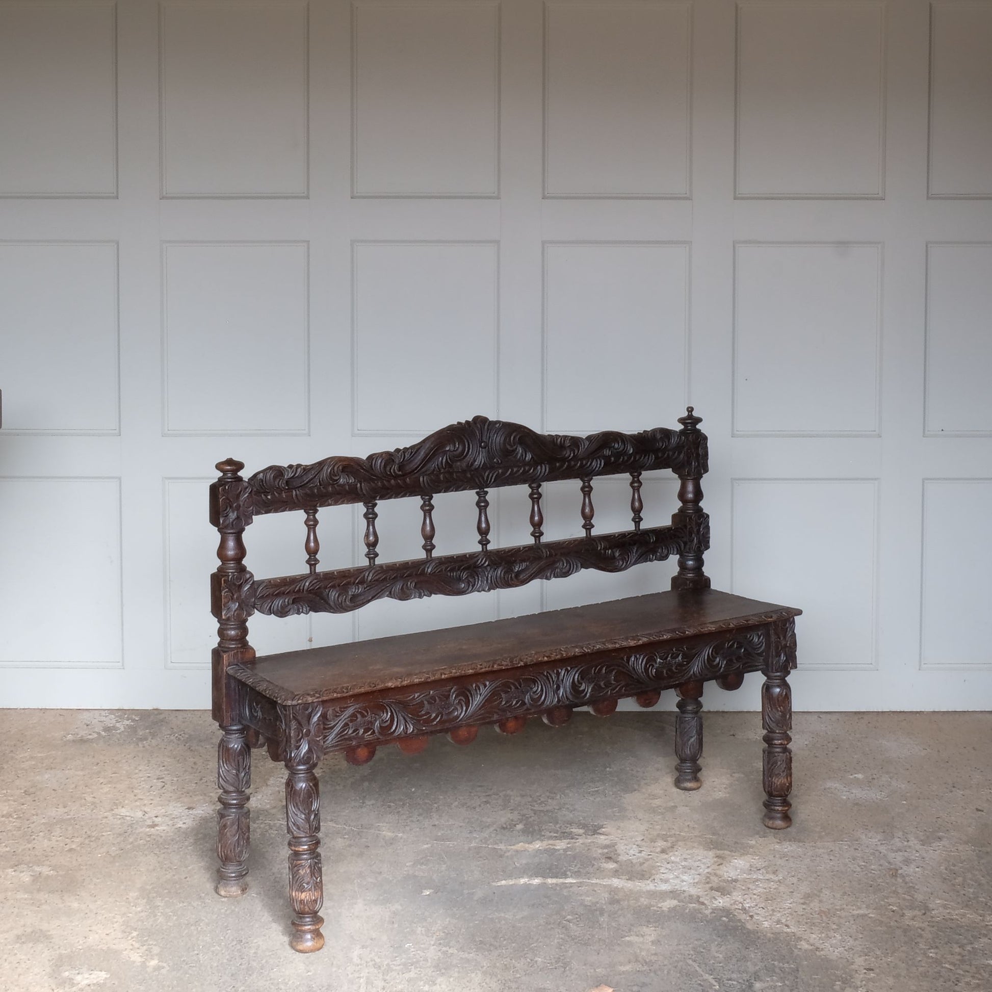 A small oak carved bench, perfect for children, late 19th / early 20th century. With a beautiful foliate carved design. A repaired split to the back rest, in sturdy condition but showing signs of a long and well loved life.