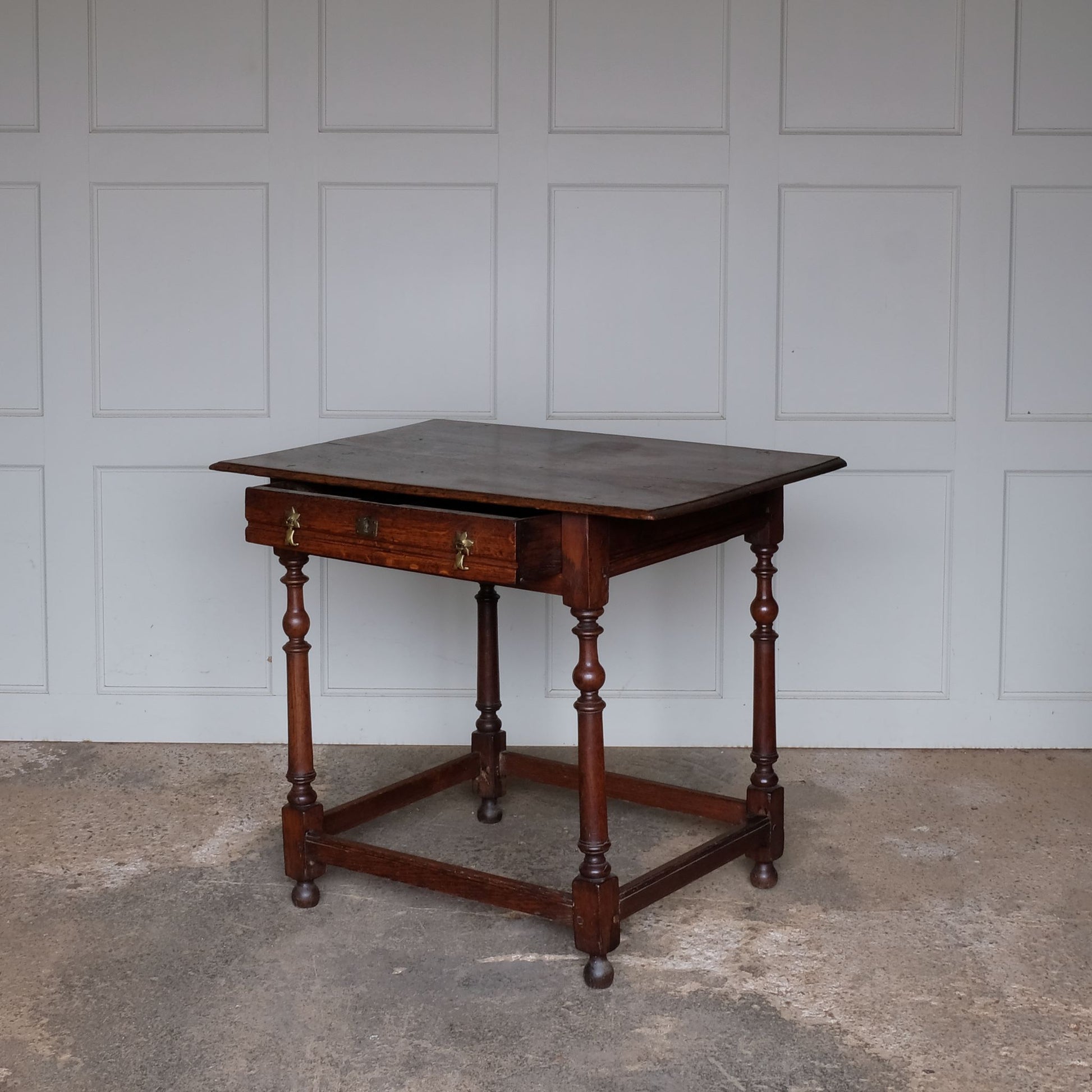 A fine 17th century English oak side table with a lovely well-patinated two plank moulded top with with flying overhangs above a single drawer over tapered and ring-turned legs joined by box stretchers. A very useful size for use in either a living room, small hallway or as an elegant bedside table.