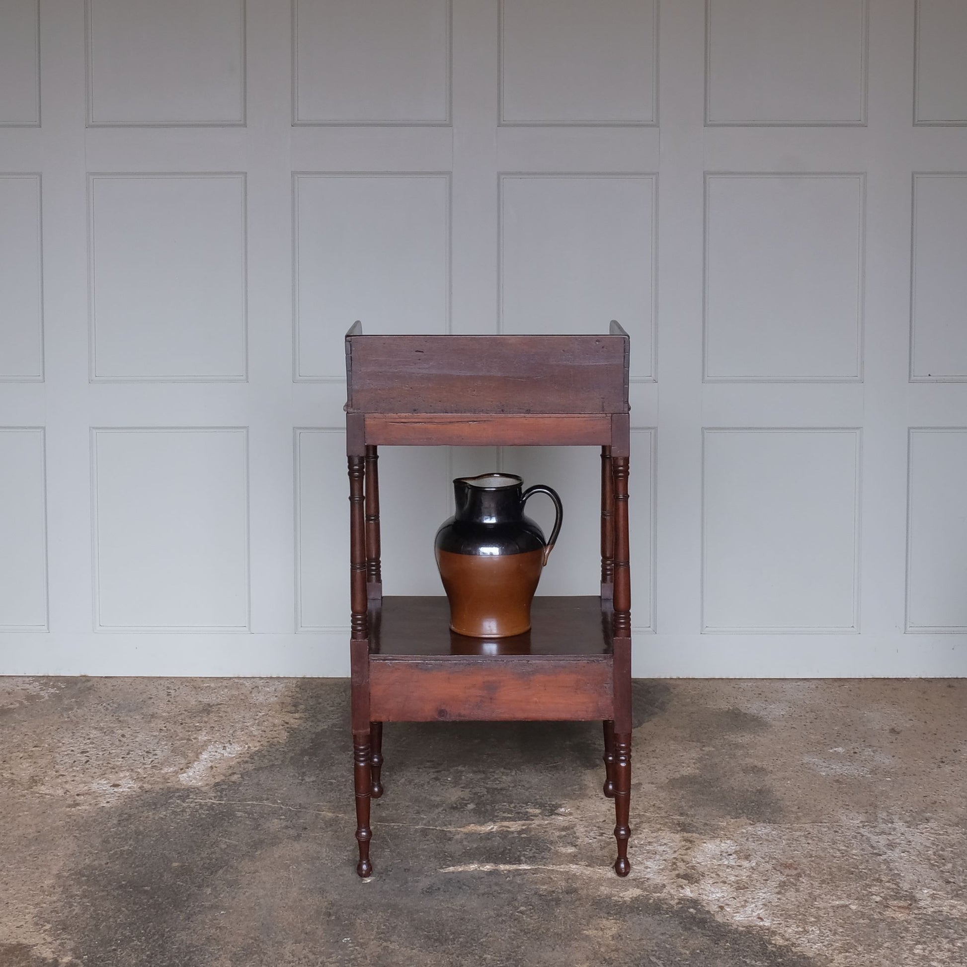 A charming early Victorian mahogany washstand, the three quarter gallery with a basin recess on turned and ringed uprights, over a single shelf with drawer over turned and ringed legs, also comprising a later stoneware basin and jug, with a gentle patina and wear commensurate with age and use, otherwise in good condition.