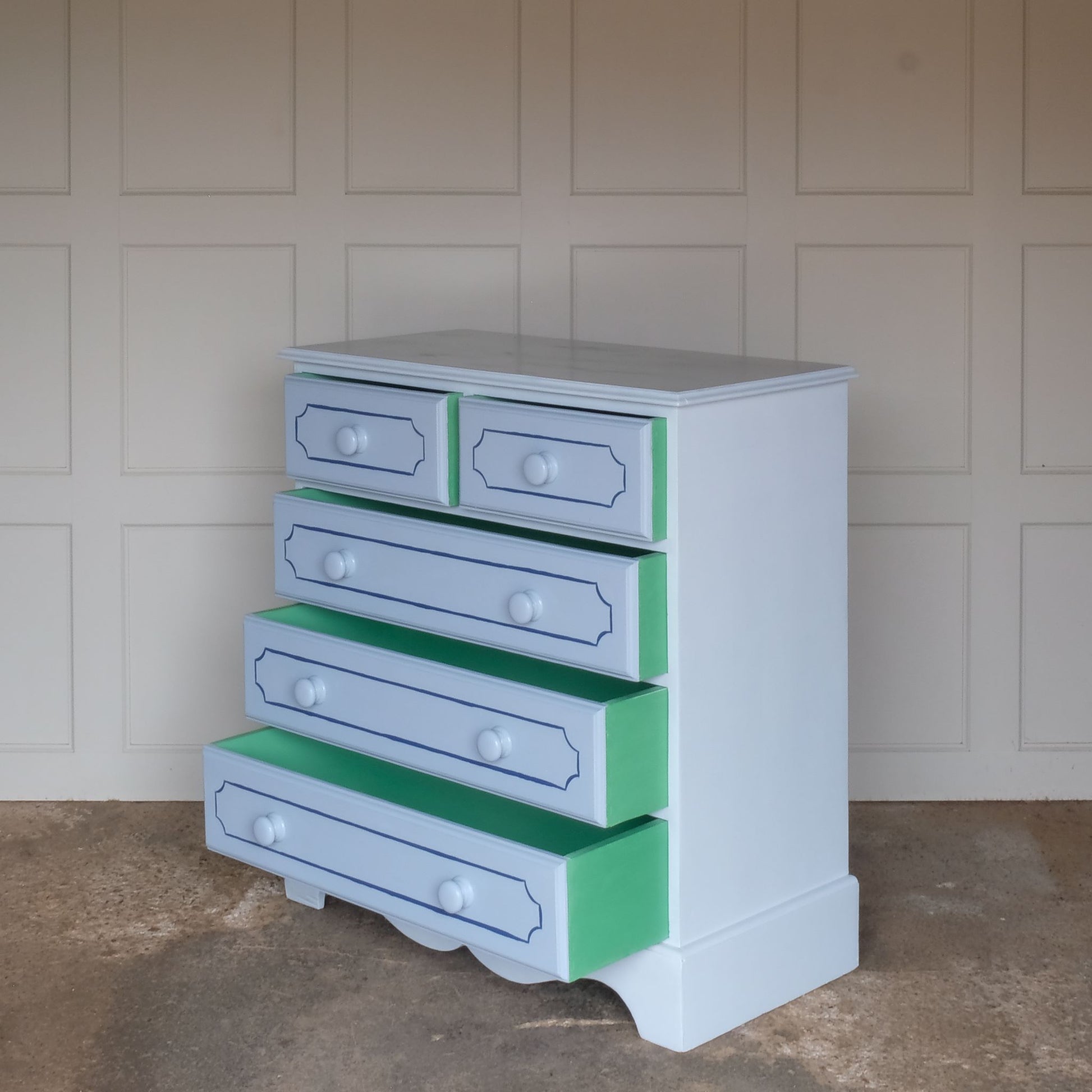 A hand painted blue pine chest of drawers, consisting of two short and three long drawers. The drawers have been painted with an elegant line detail on the front and a vibrant green to the inside and sides. The drawers are painted in a blue a shade deeper than the main body of the chest. In good sturdy condition, with all drawers running smoothly.
