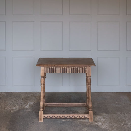 A lovely sized and charming oak side table, with a three plank top over an elegantly carved frieze, on turned legs with square feet, joined by stretchers with yet more carved detail. In very good, sturdy condition.