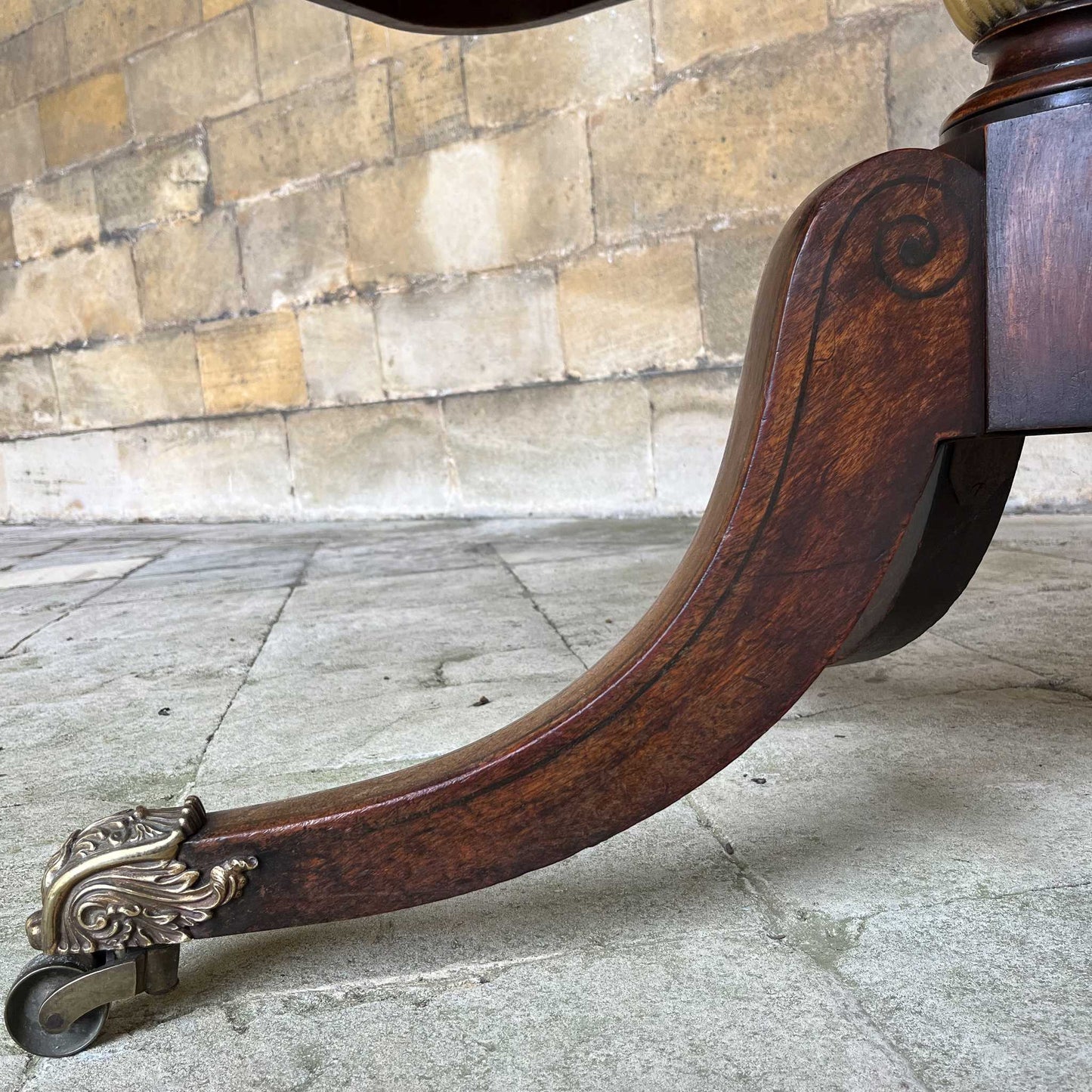 A fine Regency brass inlaid breakfast table, the rounded rectangular crossbanded tilt-top upon a turned and part gilt column support on four splayed legs with elegant tulipwood spiral inlay, showing a patina and wear commensurate with age and use, otherwise in very good condition