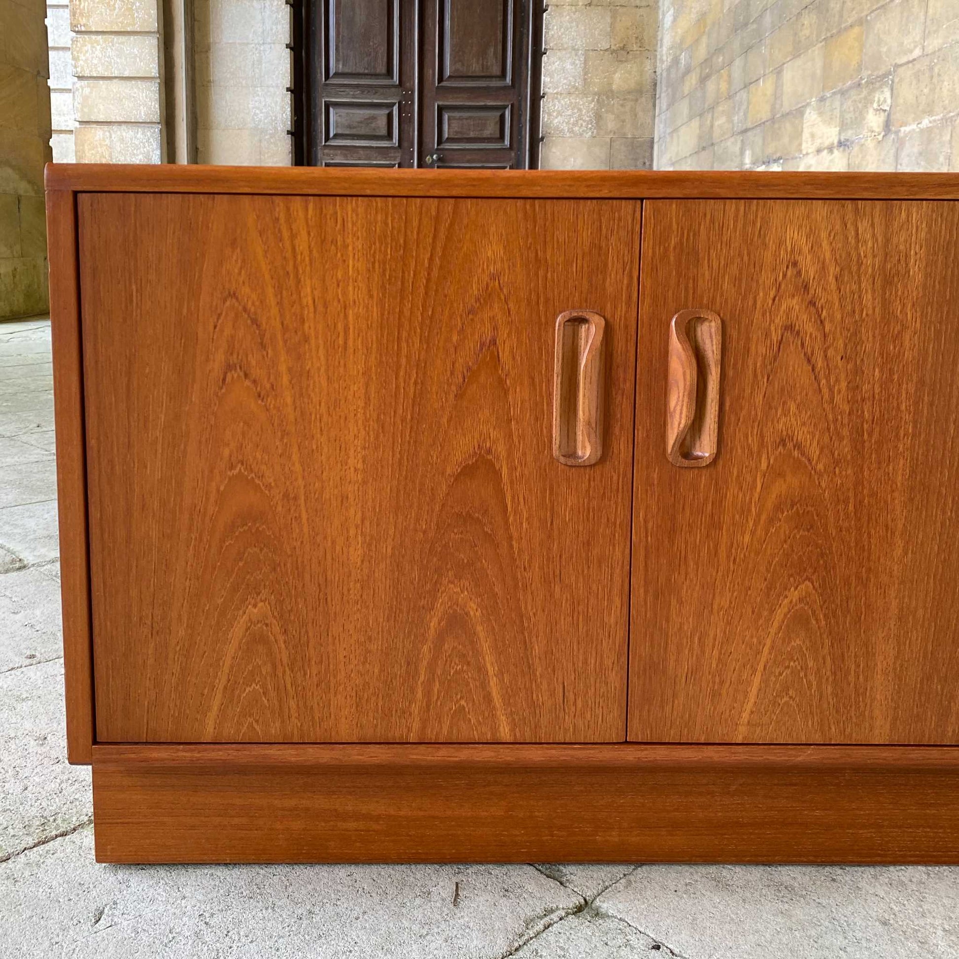 A low teak mid century sideboard by G Plan. Two spacious cabinets, each with a pair of doors and single internal shelf. The maker's mark is present inside one of the doors. In lovely condition, with some very light marks to the top, commensurate with the item's age.