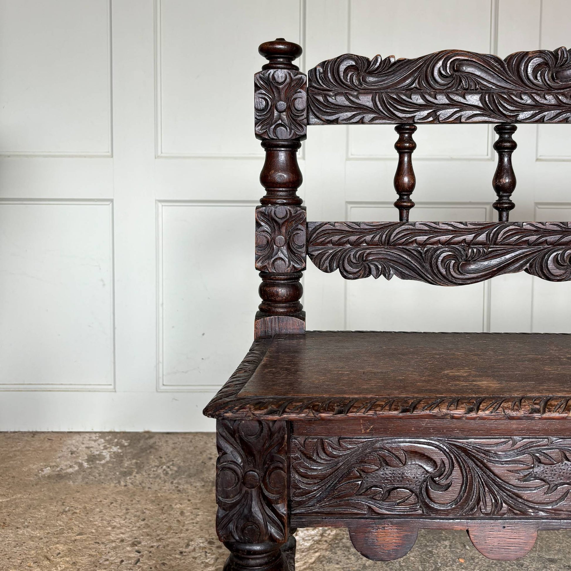 A small oak carved bench, perfect for children, late 19th / early 20th century. With a beautiful foliate carved design. A repaired split to the back rest, in sturdy condition but showing signs of a long and well loved life.