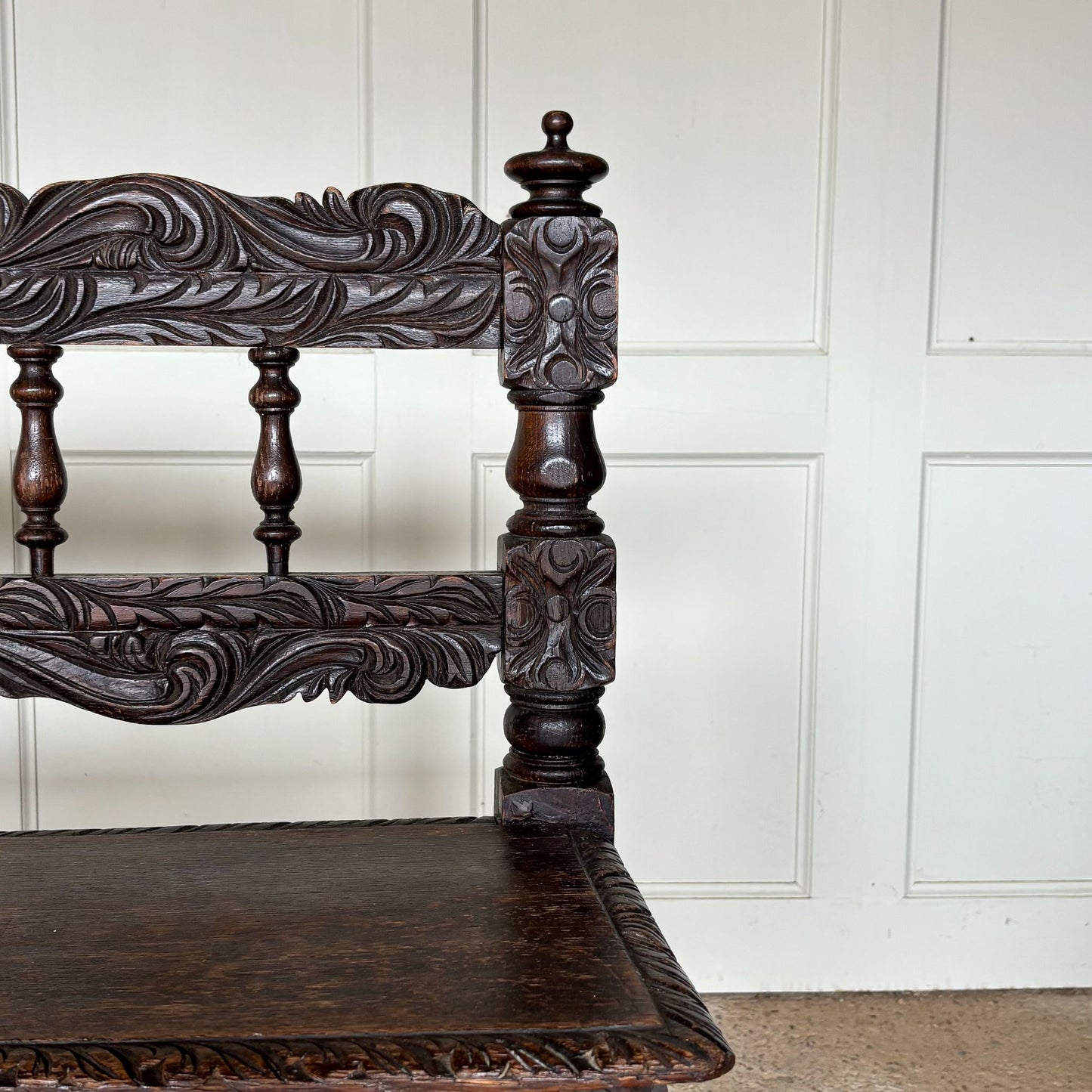 A small oak carved bench, perfect for children, late 19th / early 20th century. With a beautiful foliate carved design. A repaired split to the back rest, in sturdy condition but showing signs of a long and well loved life.