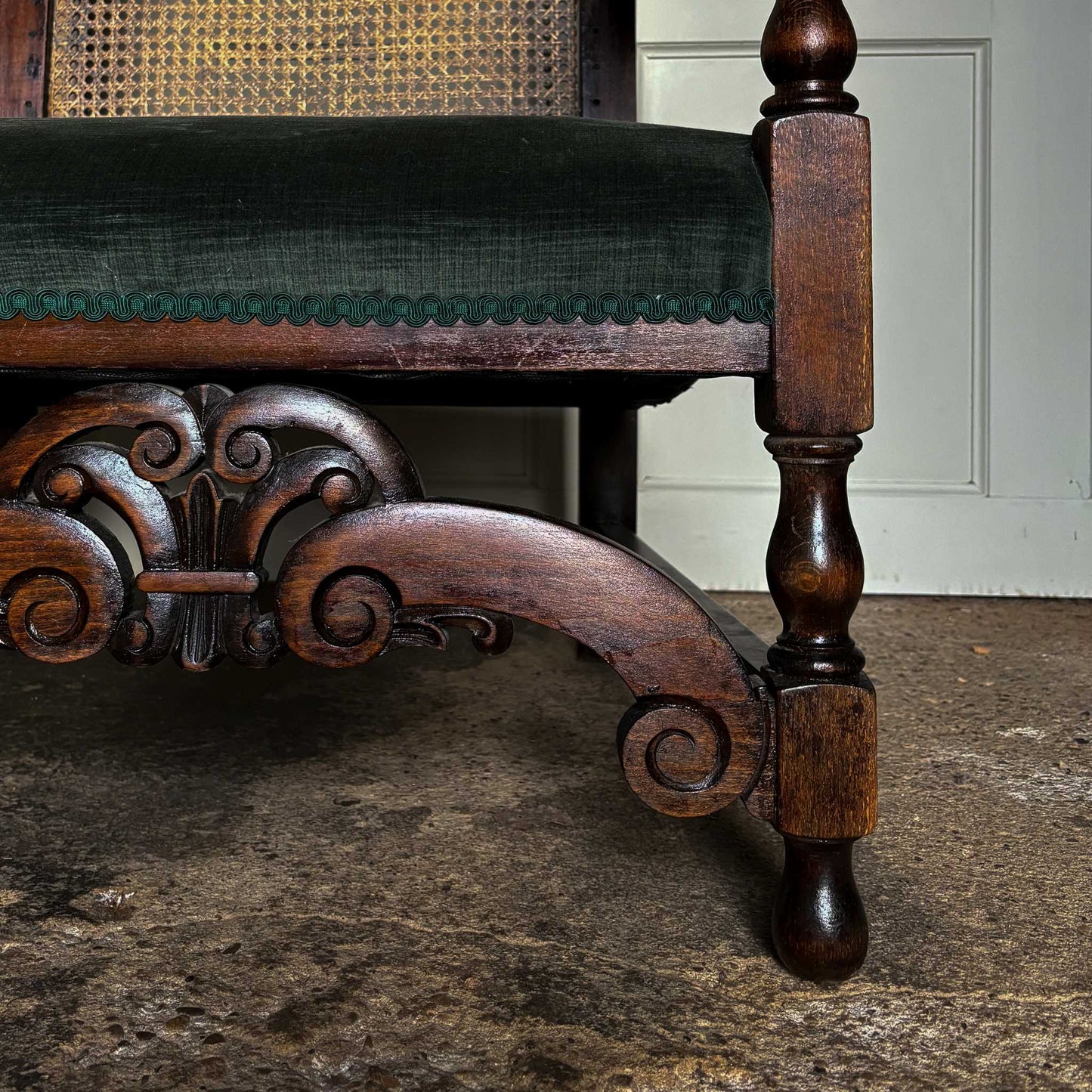 An elegant two seater 19th century settee with a two part cane panelled backrest, newly reupholstered in a dark green velvet and matching green braiding. Masterfully restored by Anthony Beech ACR and in excellent structural condition.