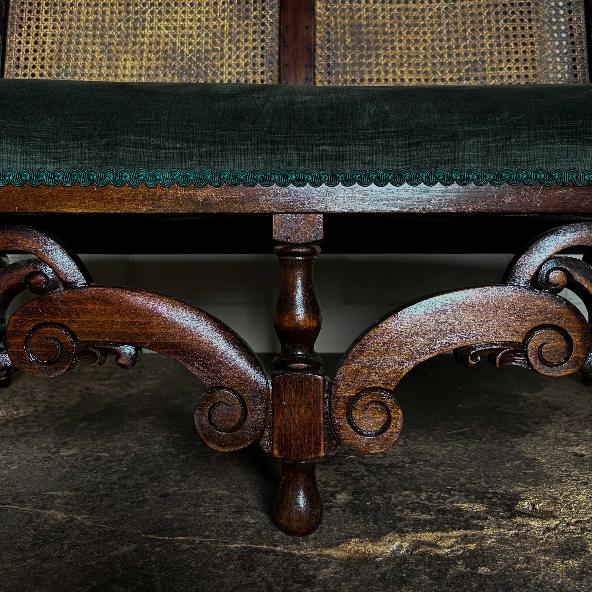 An elegant two seater 19th century settee with a two part cane panelled backrest, newly reupholstered in a dark green velvet and matching green braiding. Masterfully restored by Anthony Beech ACR and in excellent structural condition.