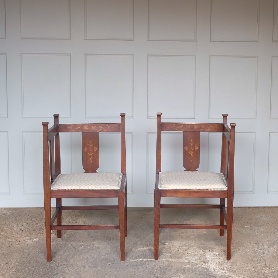 A pair of Arts and Crafts inlaid mahogany corner chairs side by side, with recently upholstered seat pads - by Summerfield & Scott
