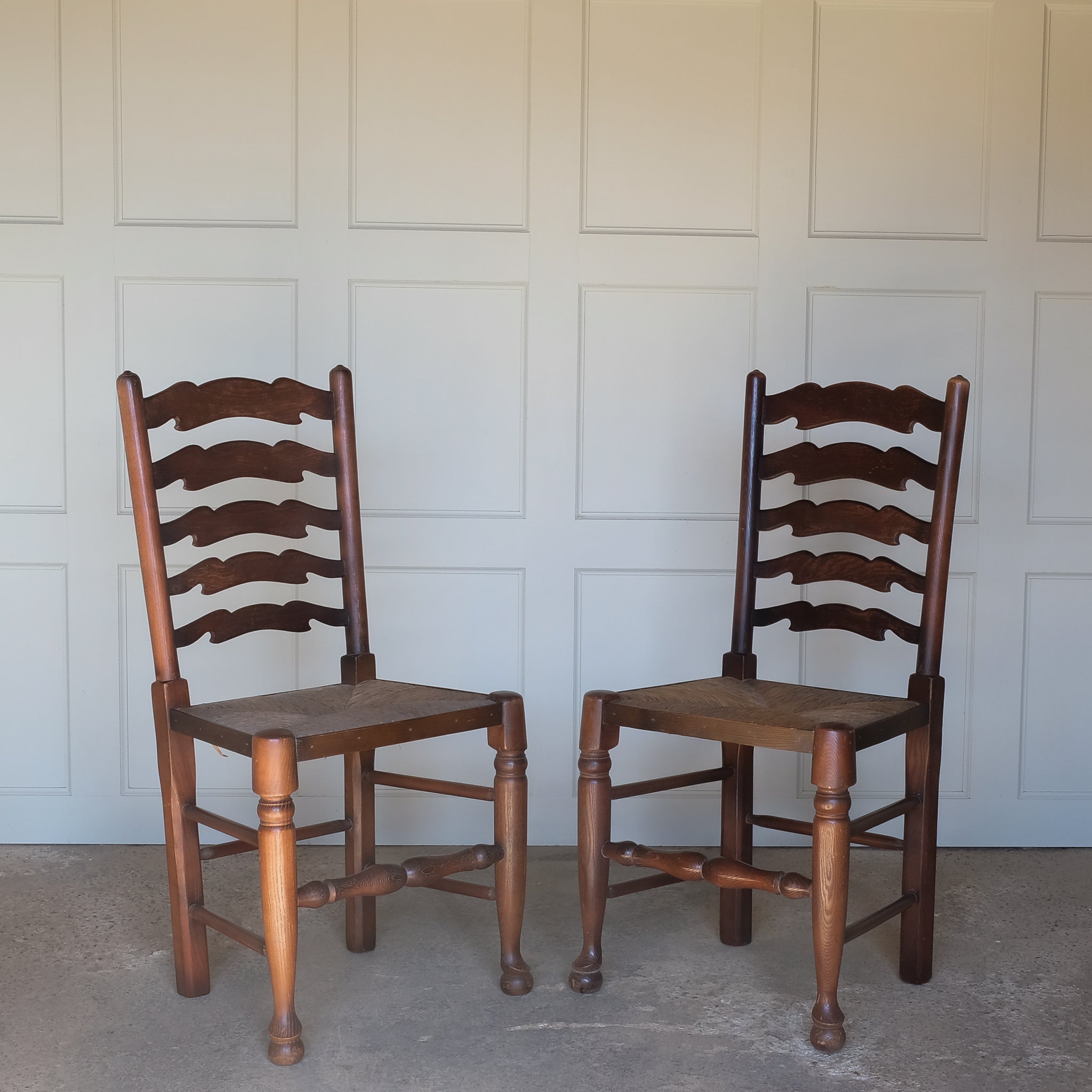 A PAIR OF OAK LADDER BACK CHAIRS