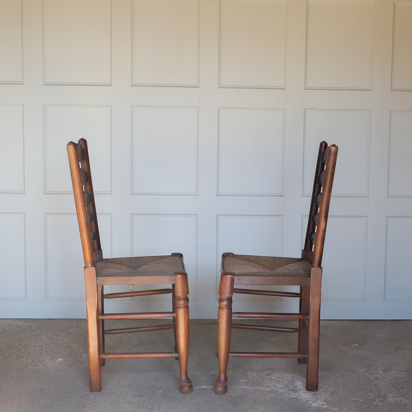 A PAIR OF OAK LADDER BACK CHAIRS