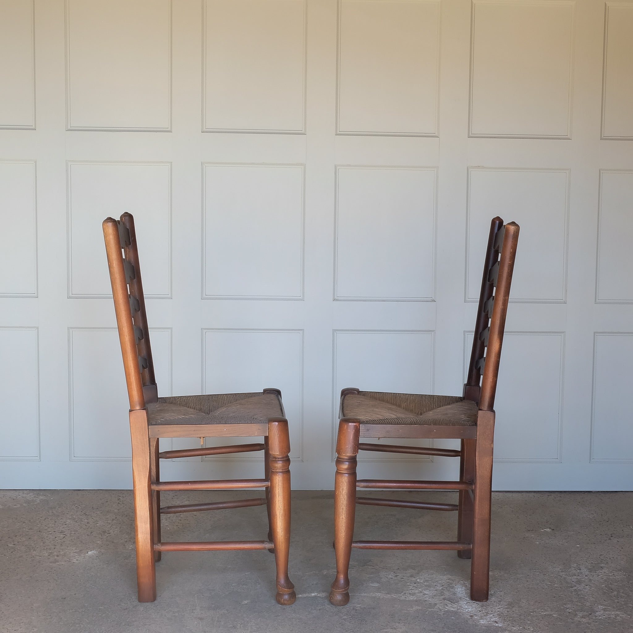 A PAIR OF OAK LADDER BACK CHAIRS