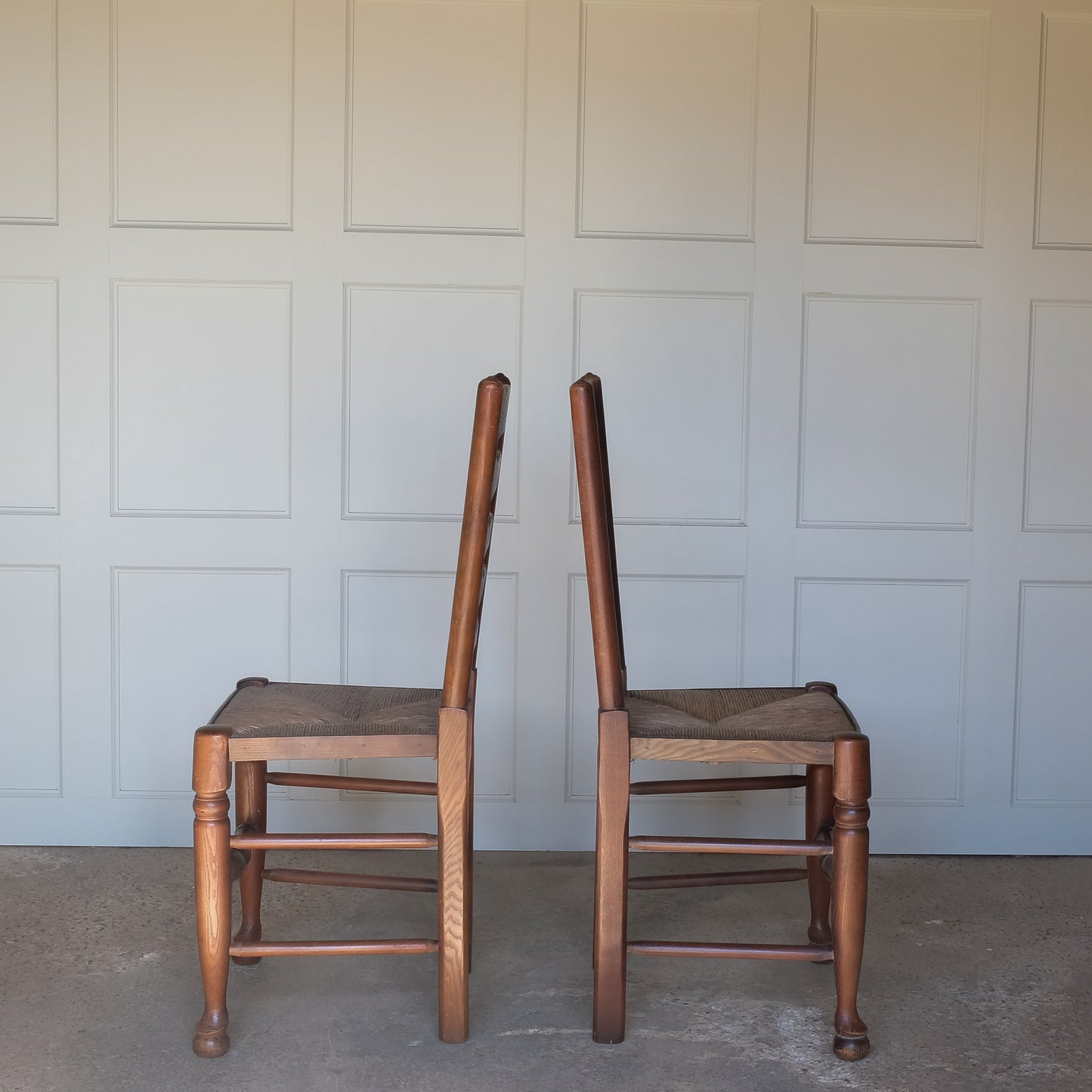 A PAIR OF OAK LADDER BACK CHAIRS